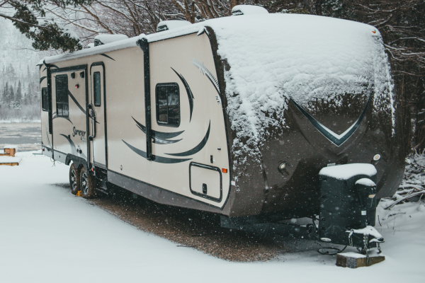 RV parked outside in snow - benefits of indoor RV storage