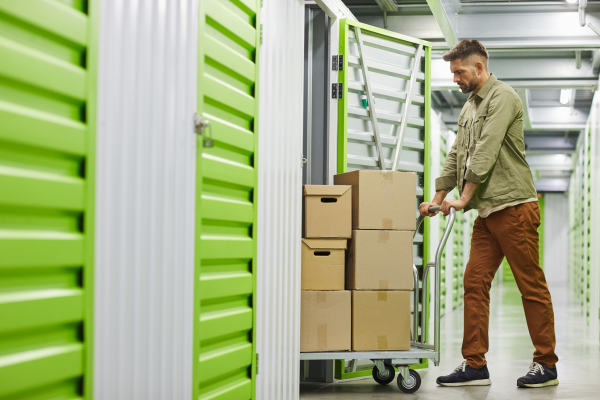 Man putting boxes inside of a storage unit - secure storage
